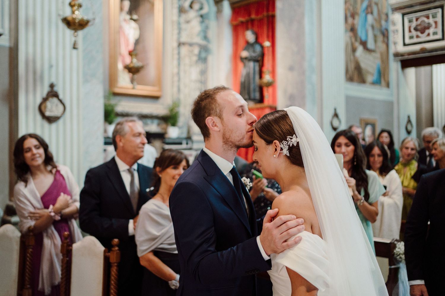 bacio sposo alla sposa sulla fronte dopo il suo ingresso