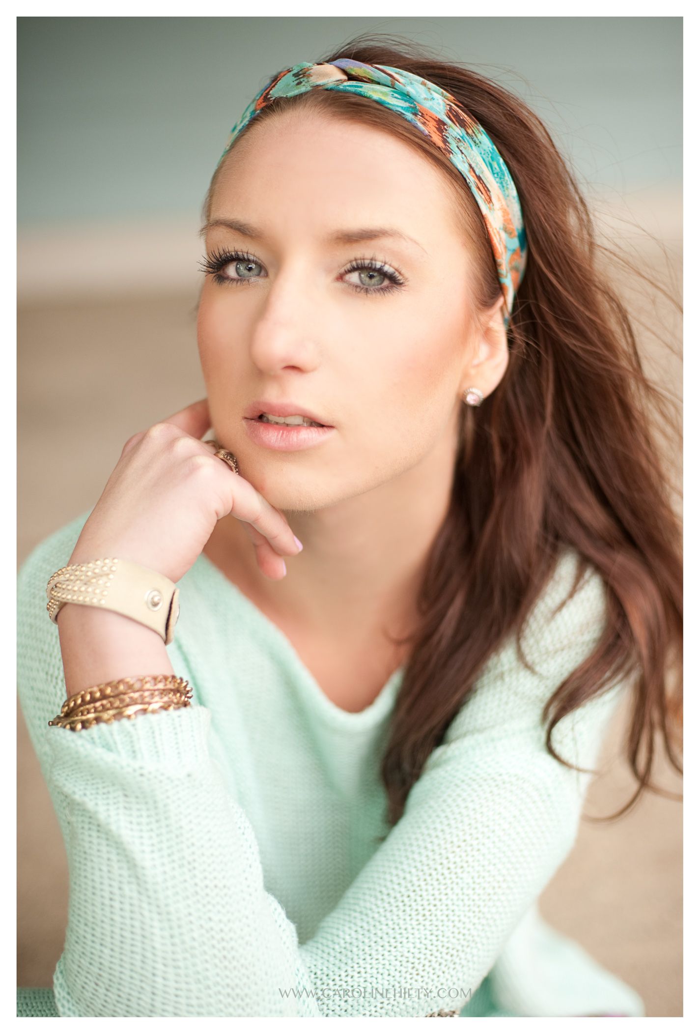 Fashion portrait featuring a cozy mint sweater, turquoise headband, and delicate gold jewelry in soft lighting.
