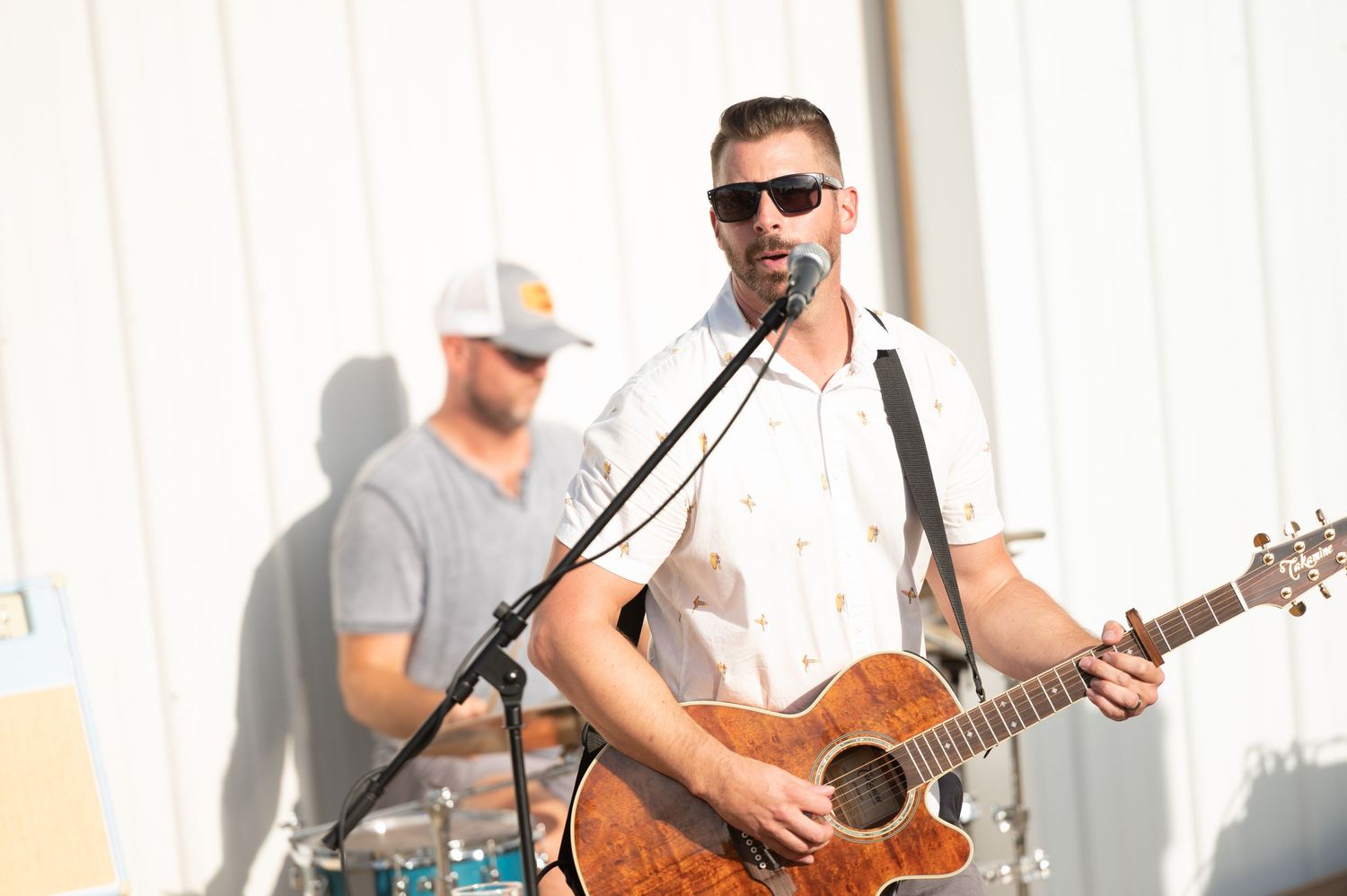 Musicians performing with guitars and instruments on stage during a live performance.