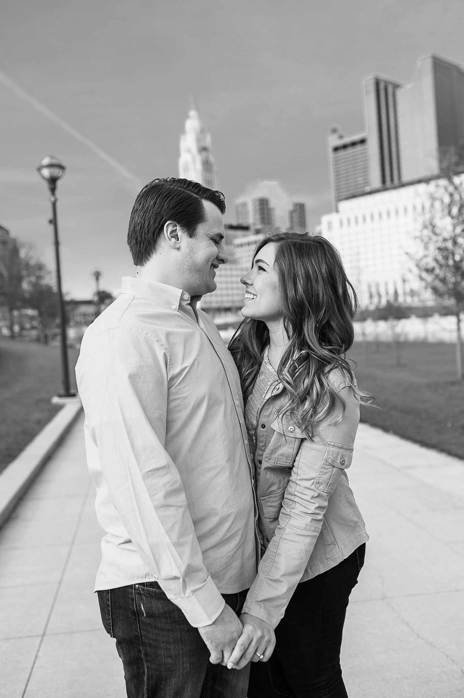 Black and white photo of a couple sharing an intimate moment on urban steps.