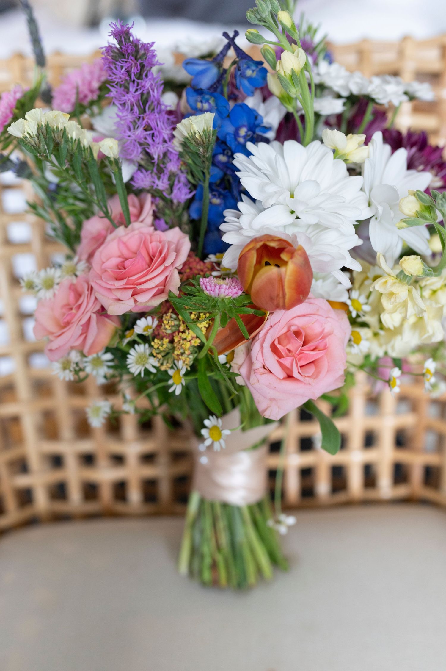 Colorful wedding bouquets with pink roses, purple flowers, and white daisies.