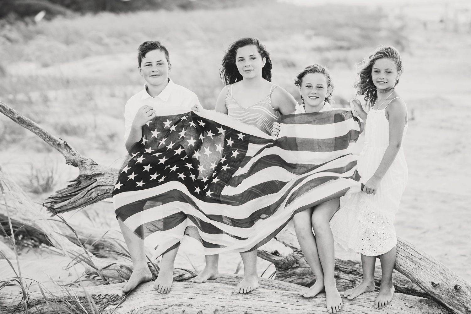 A vintage black and white photo of children holding an American flag on the beach.Hammock Beach, Sea Pines coastal photography.