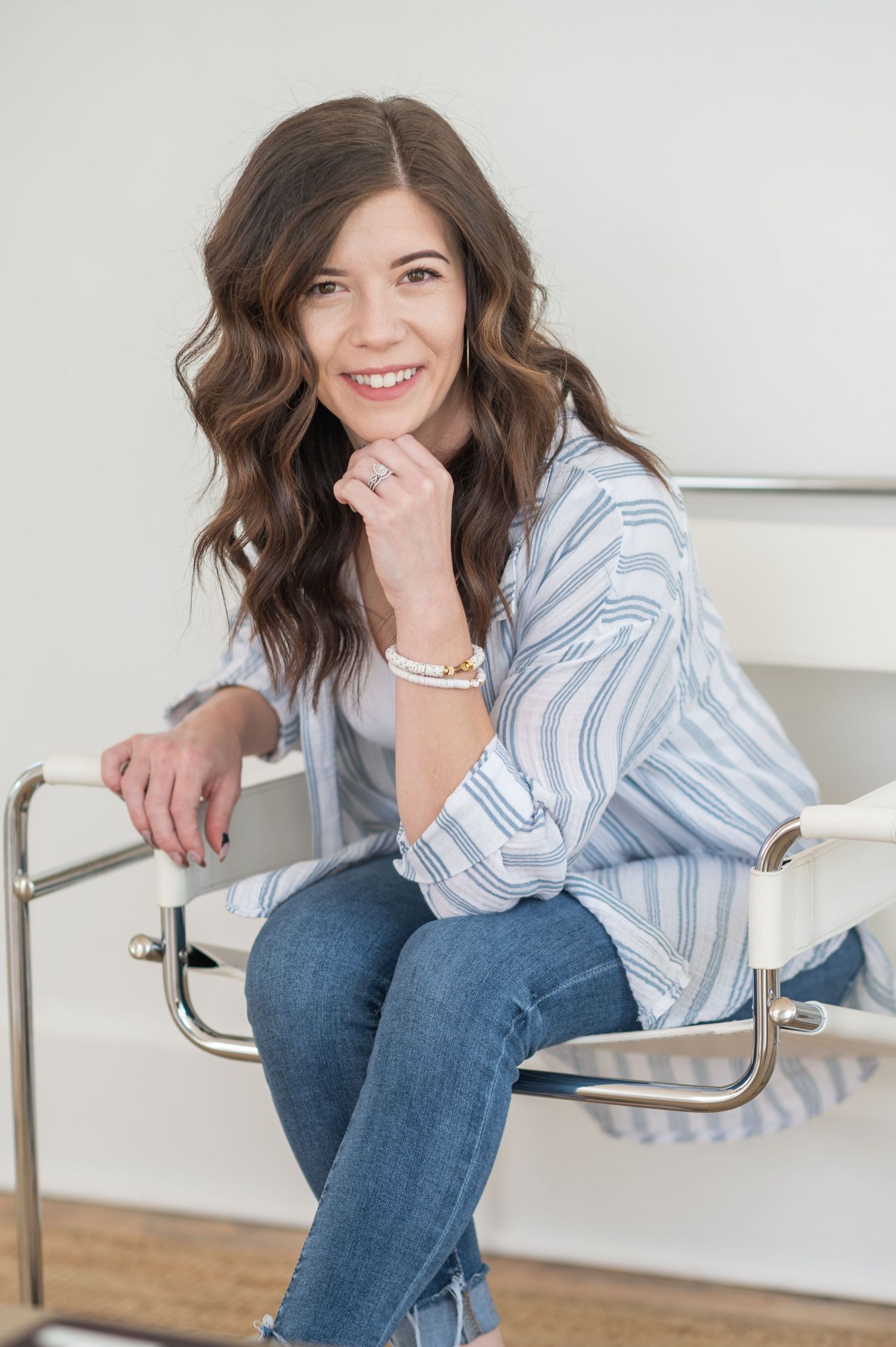 Casual portraits on staircase wearing striped shirt and jeans with relaxed poses.