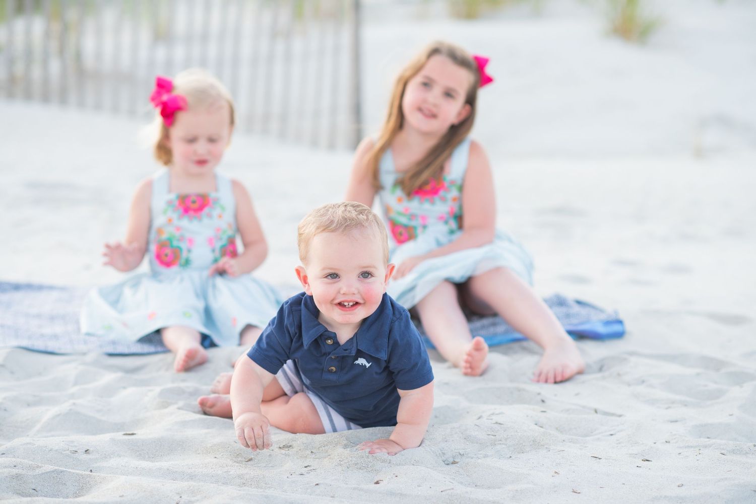 Children playing and laughing together on a white sandy beach.