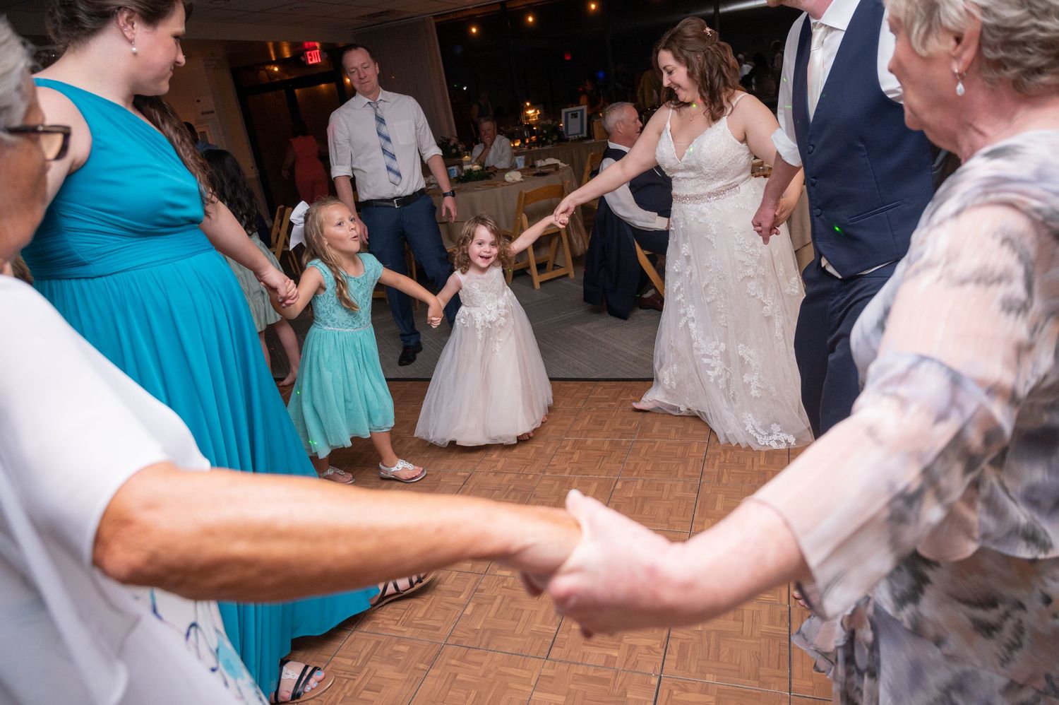 Wedding guests dancing and celebrating during evening reception party.