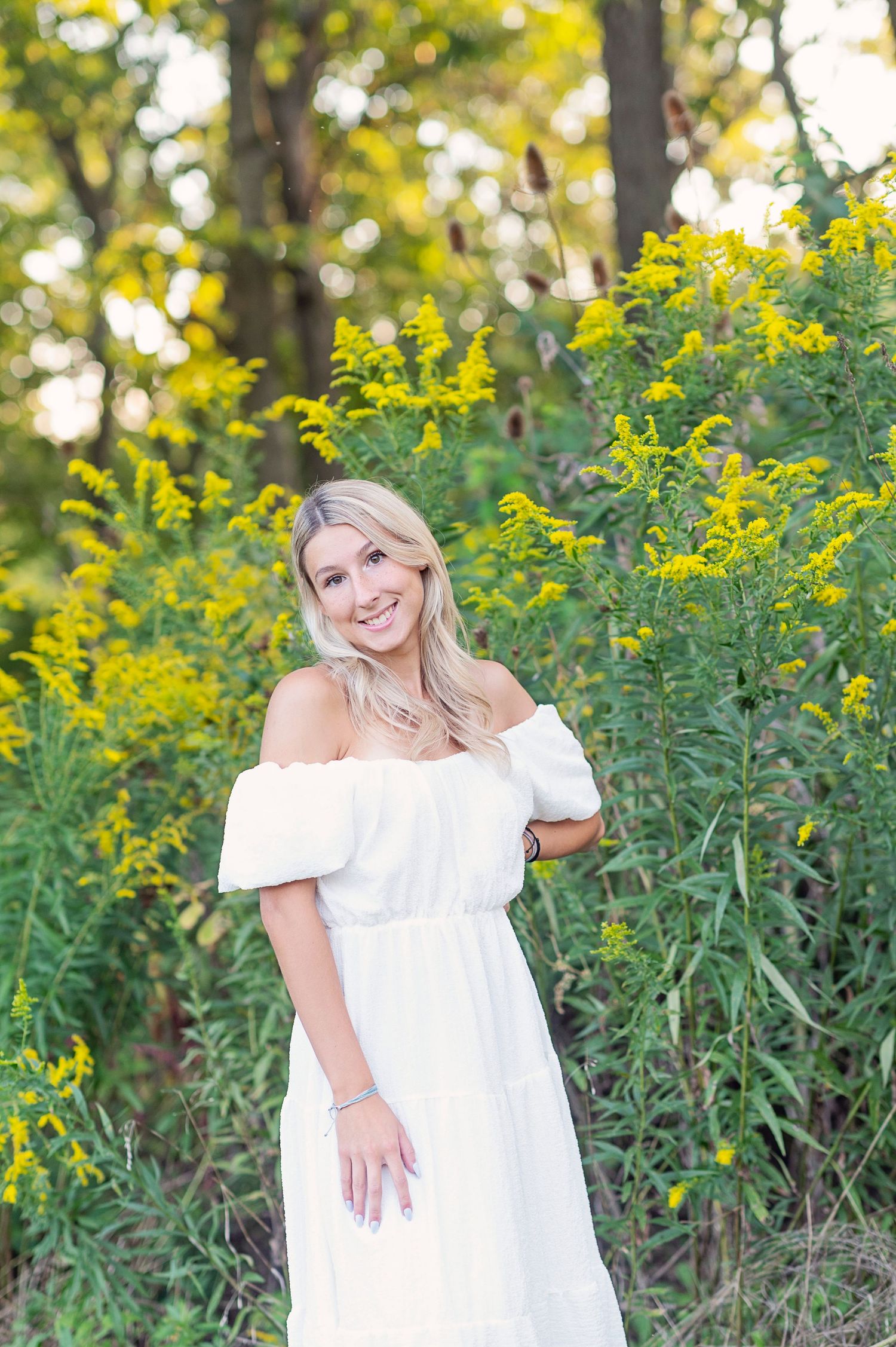 A summer portrait amidst blooming yellow wildflowers and natural greenery.