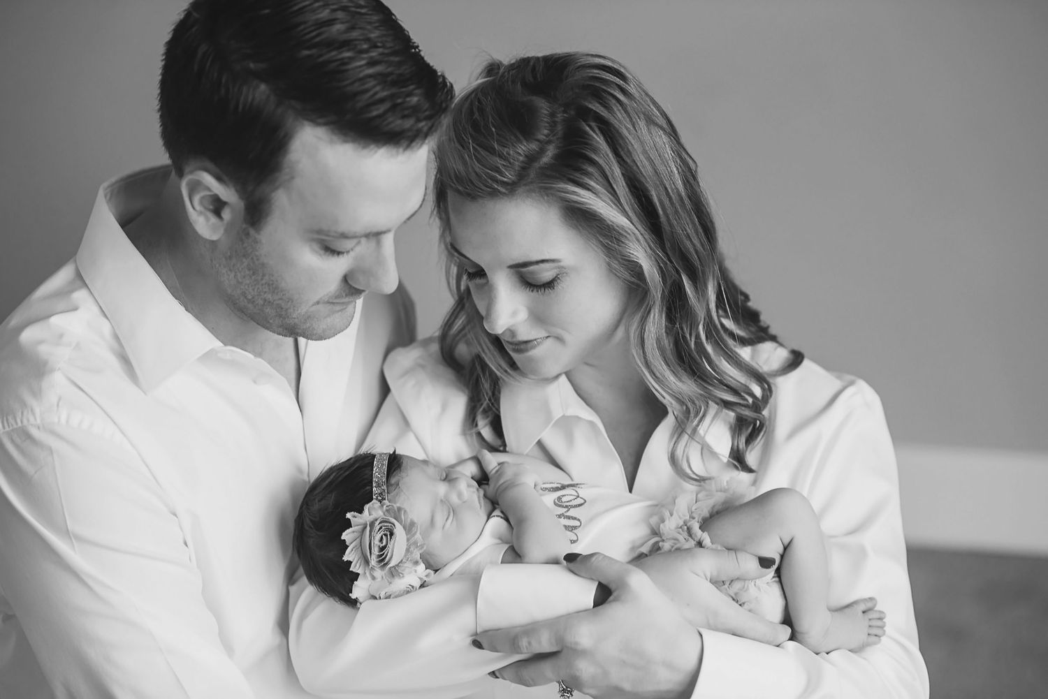 Intimate black and white family portrait in studio setting.
