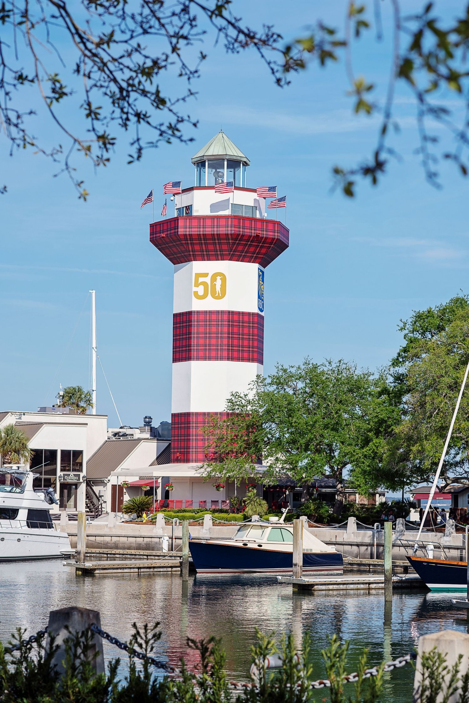 Harbor marina with distinctive red and white lighthouse towers and docked boats. Hilton Head Island photographer.