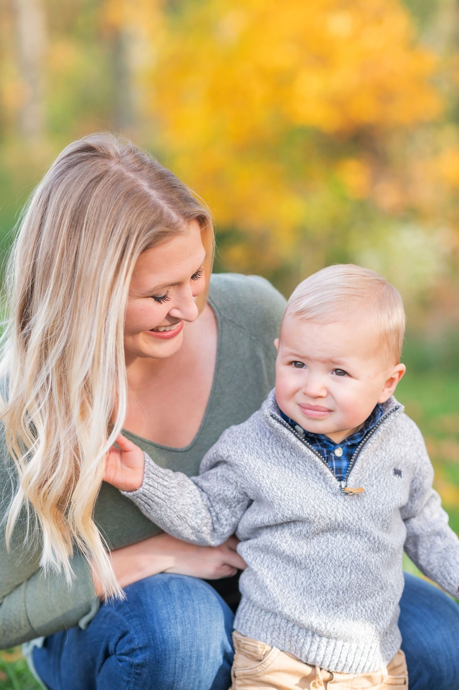 A heartwarming moment between parent and child during an autumn outdoor photo session.