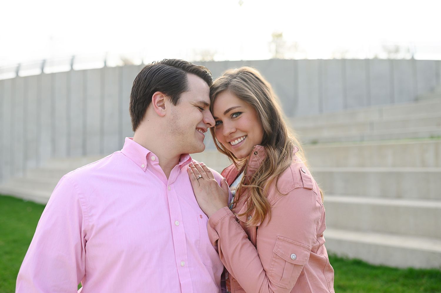 Romantic couple poses together against an urban backdrop in springtime.