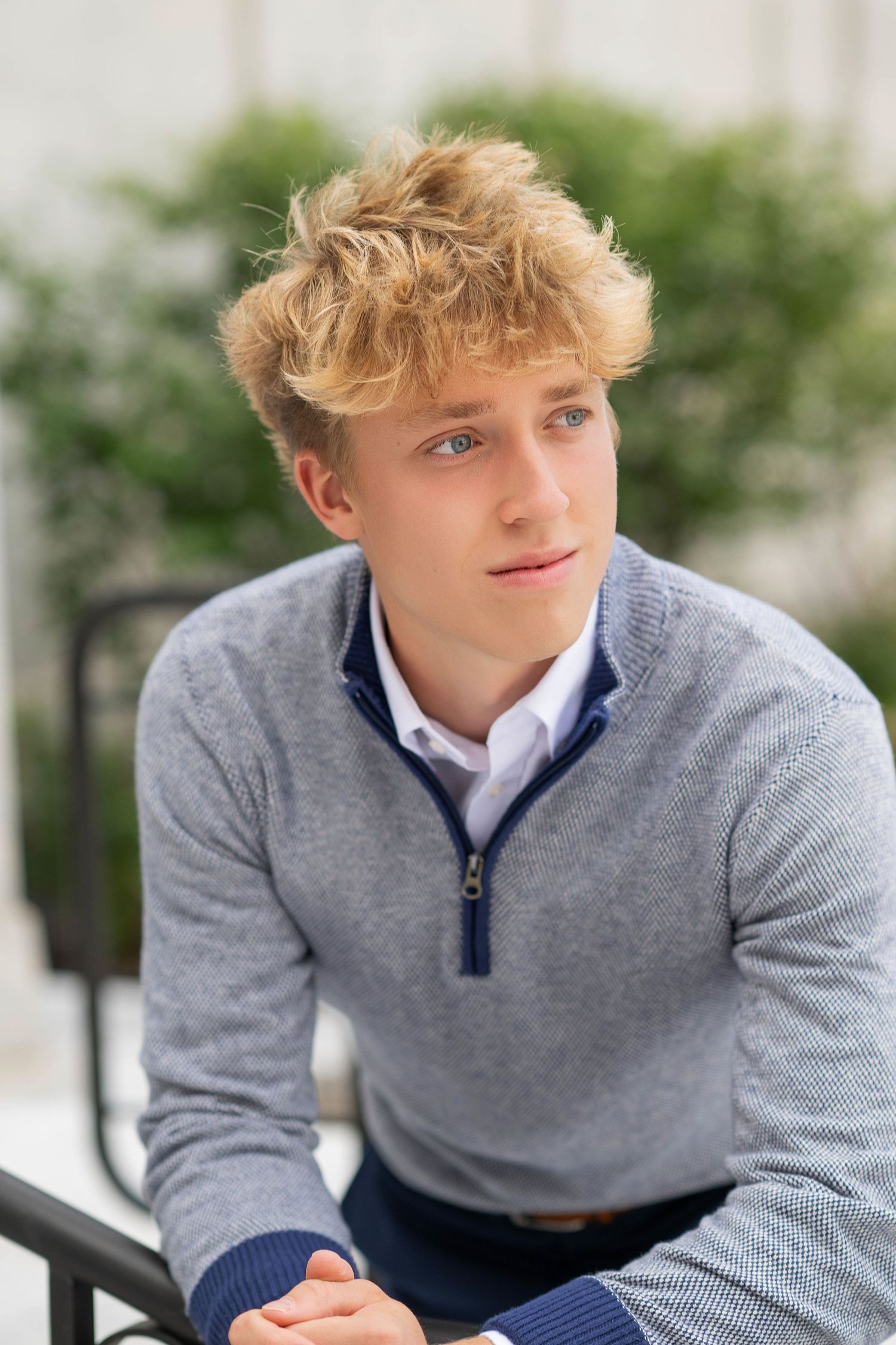 Person wearing a gray quarter-zip sweater poses outdoors in a series of casual portrait shots.