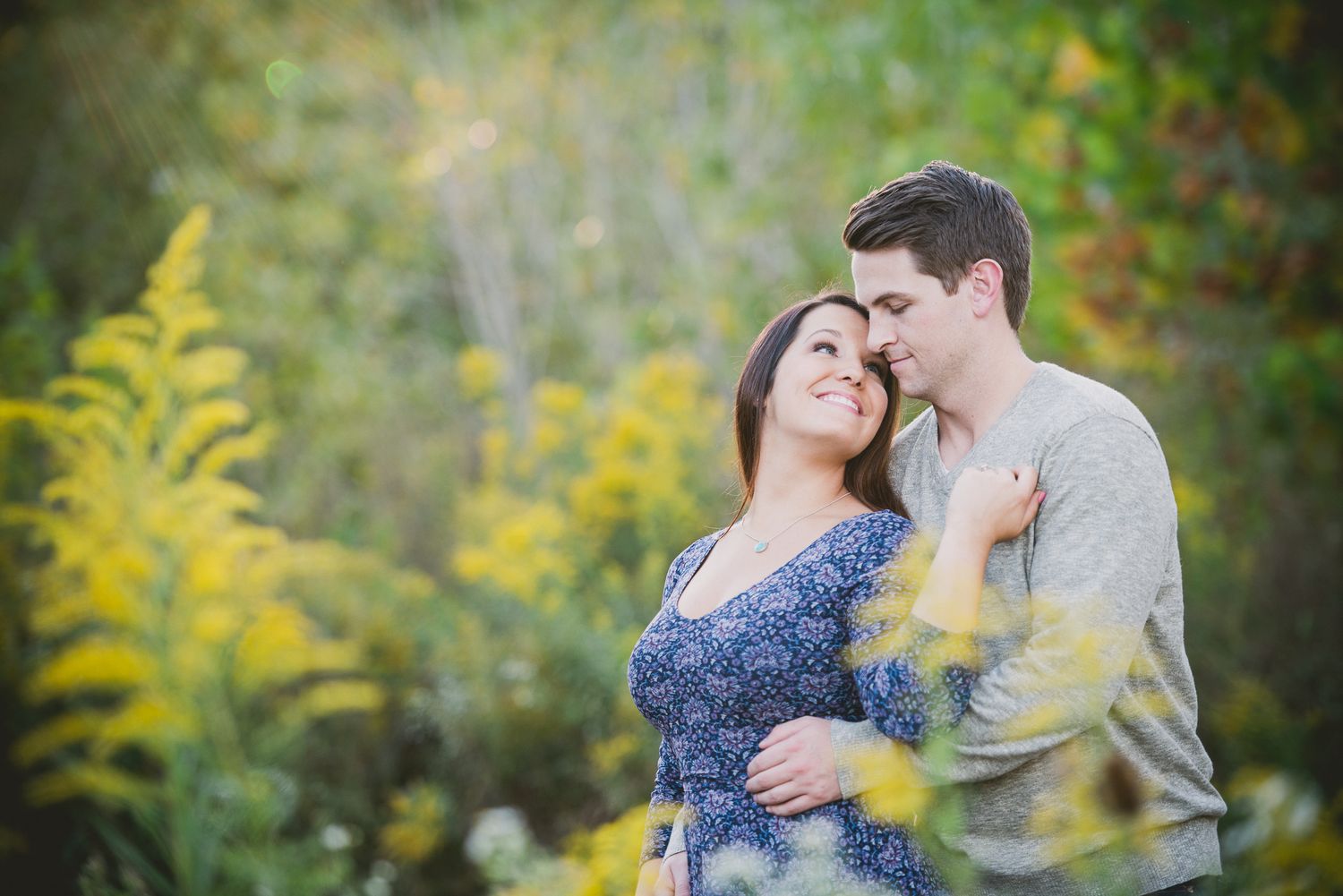 Engagement session Romantic couple portrait with golden wildflowers and natural lighting.