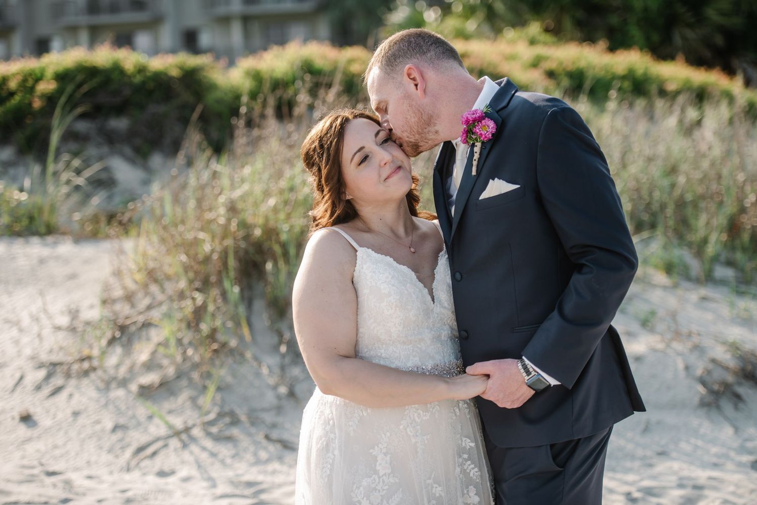 Romantic beach wedding portraits with natural coastal scenery in the background.