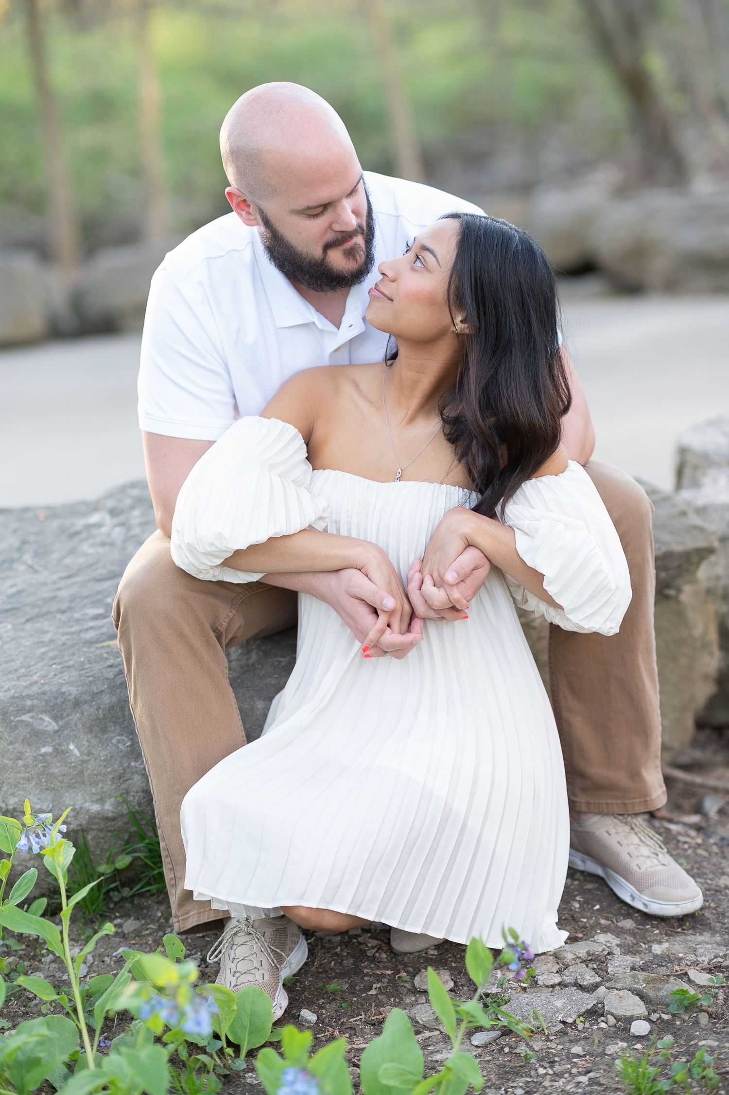Intimate couple's portrait session on rocky terrain surrounded by spring greenery. Washington Oaks Garden, Palm Coast engagement session.