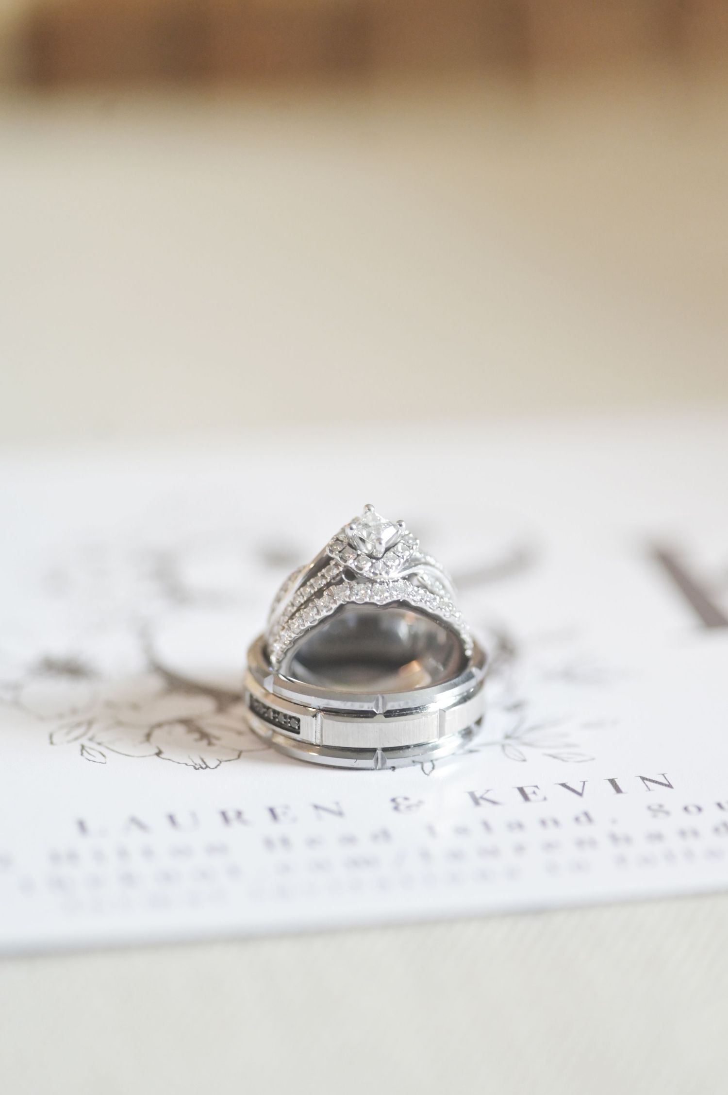 Close-up of elegant wedding rings on white paper with text.