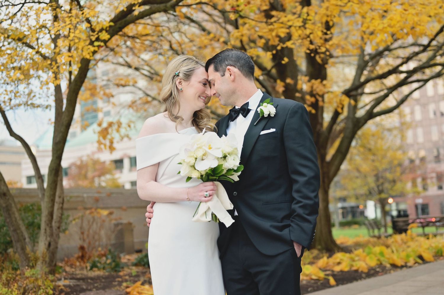 Autumn wedding portrait with golden yellow leaves in background.