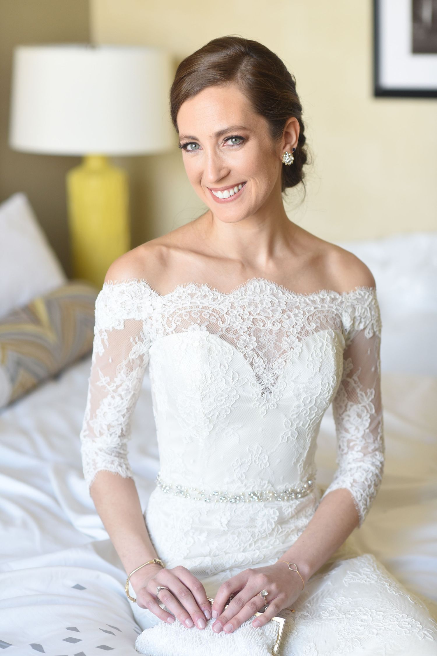 Elegant bridal portrait featuring a lace off-shoulder wedding dress with three-quarter length sleeves.