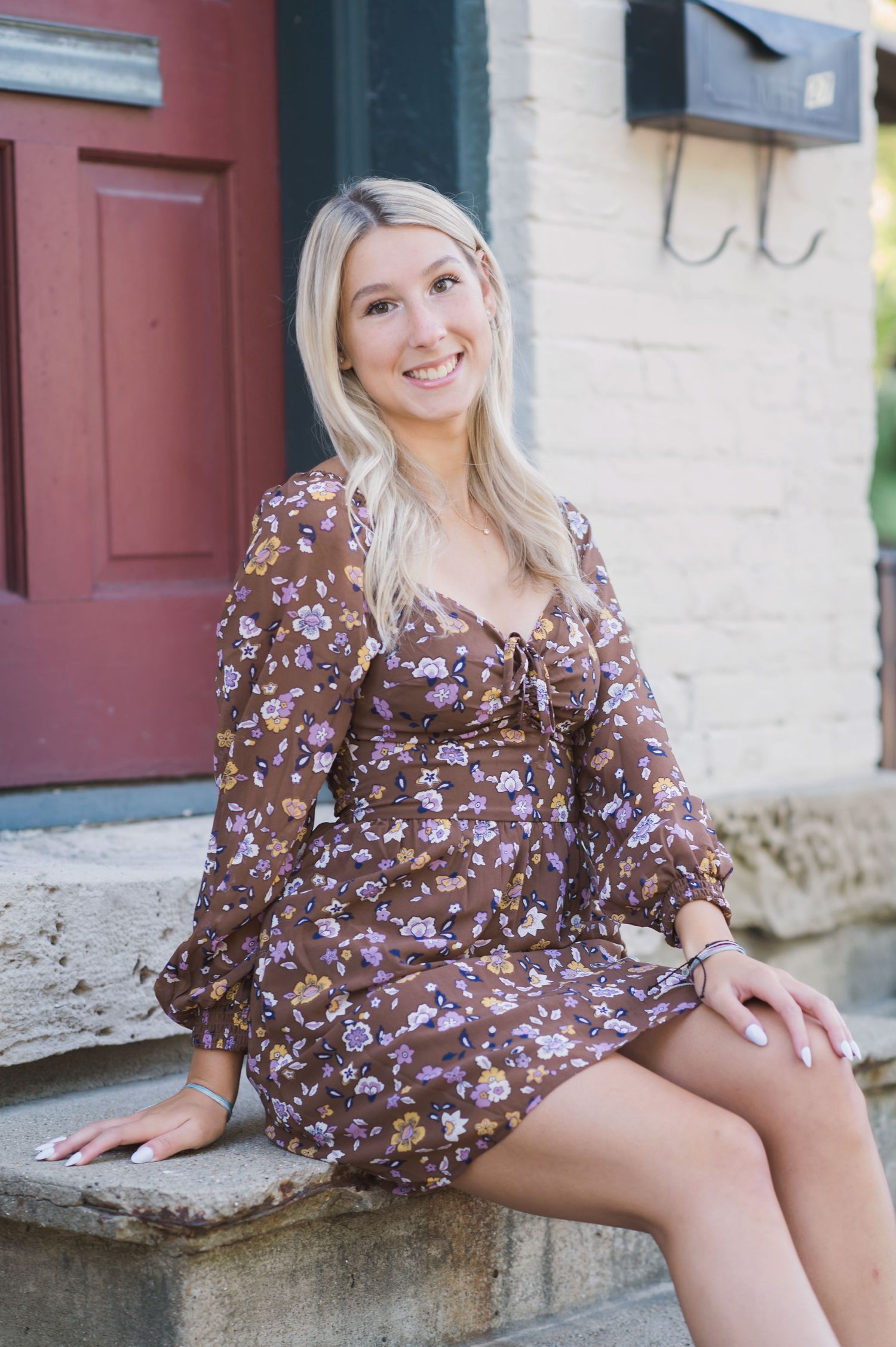 A series of outdoor portraits showing someone wearing a brown floral dress while sitting on stone steps.