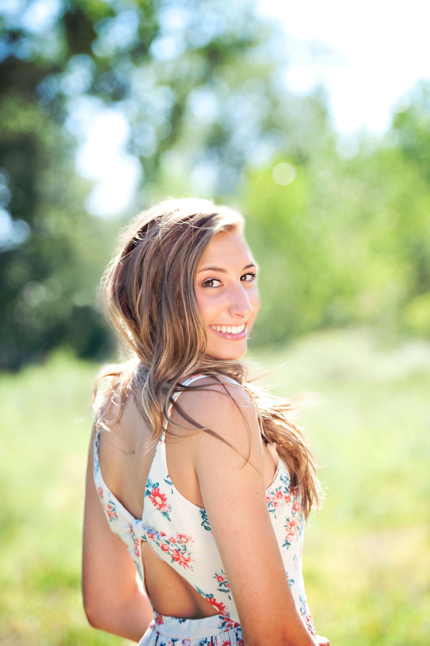 A series of four outdoor portrait shots showing someone in a floral dress with sunlit nature in the background.
