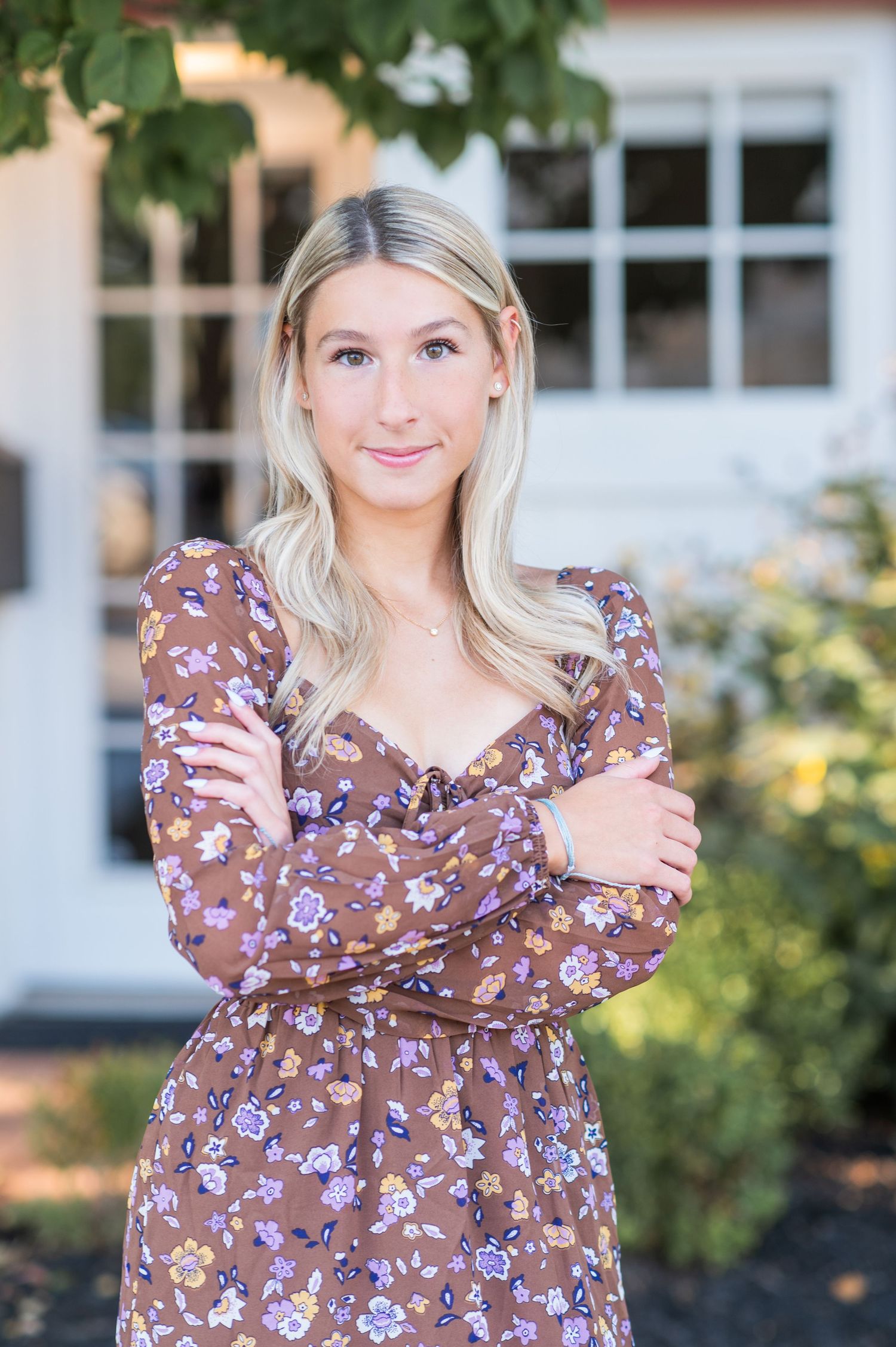A series of photos showing someone in a brown floral dress posing outdoors against a garden background.