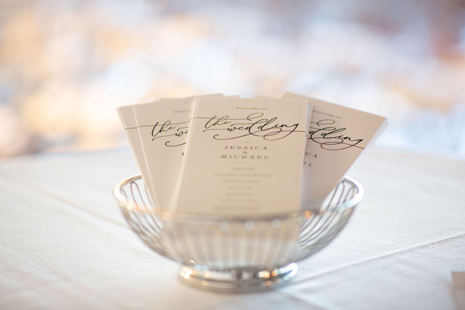Vintage handwritten recipe cards and a glass mixing bowl arranged on a white surface in soft natural light.