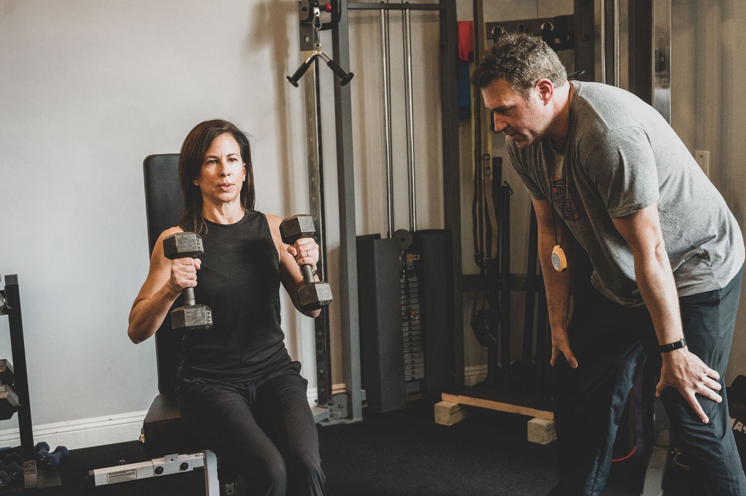 People exercising and stretching in a fitness studio with workout equipment.
