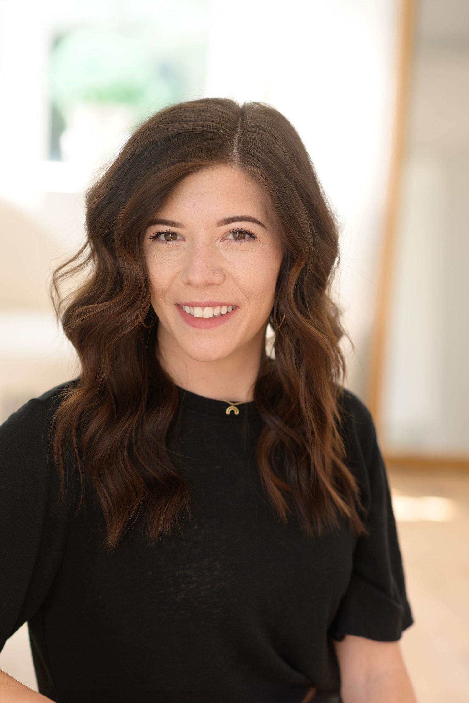Studio portraits in black top showing natural expressions and movement.