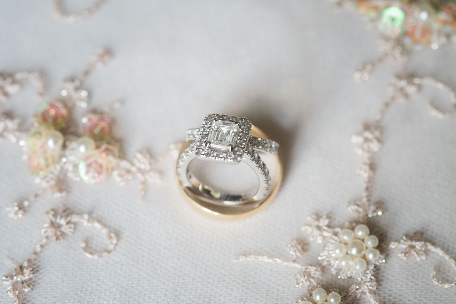 Delicate water droplets rest on intricate white lace fabric creating a shimmering, ethereal effect.