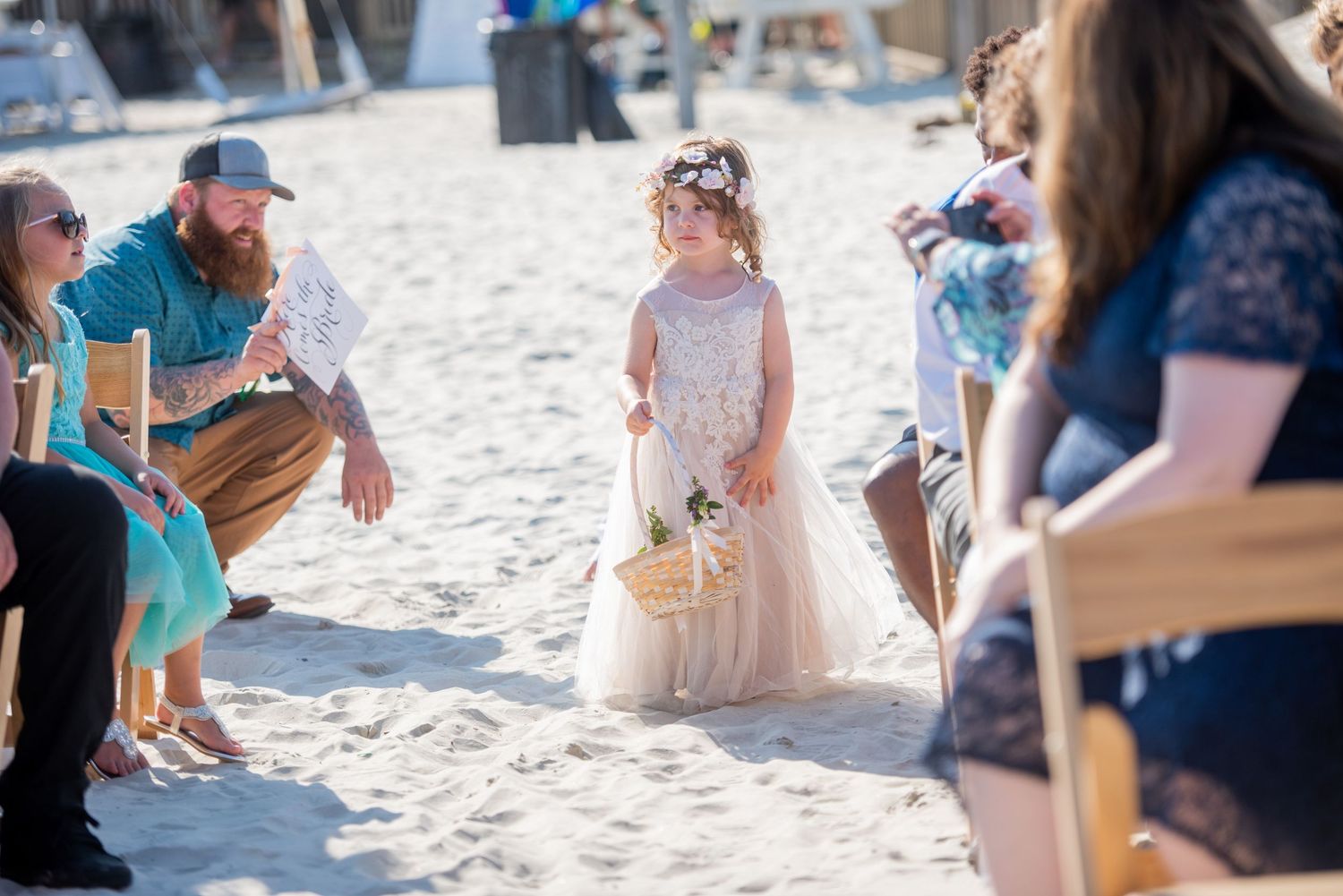Wedding guests seated on beach chairs during outdoor ceremony.