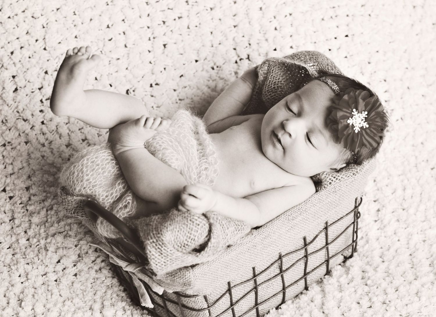 A collection of black and white artistic newborn portraits showing a sleeping baby in various peaceful poses.