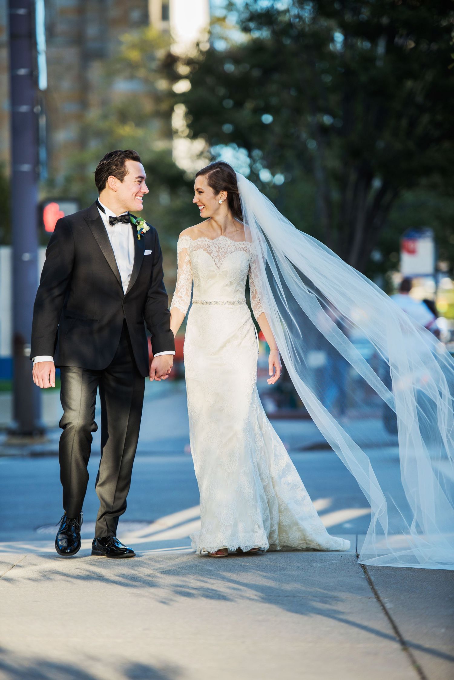 downtown Columbus, Ohio wedding couple walking together outdoors with a flowing veil catching the breeze in multiple artistic shots.