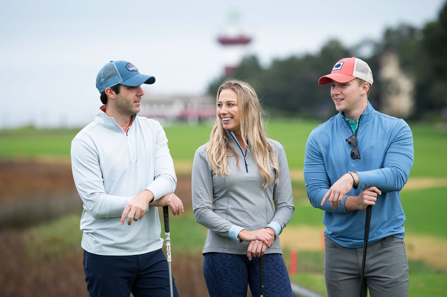 Group of golfers chatting casually on scenic coastal golf course.Sea Pines Hilton Head. Southern Tide Brand editorial photoshoot.