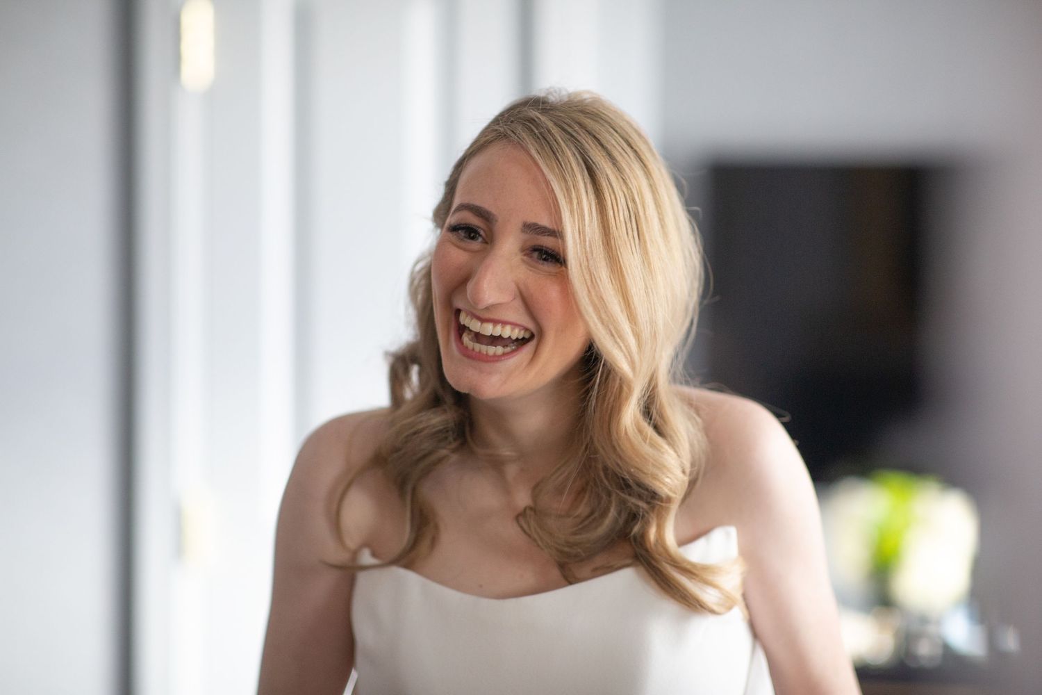Candid bridal portraits showing joyful expressions in natural window light.