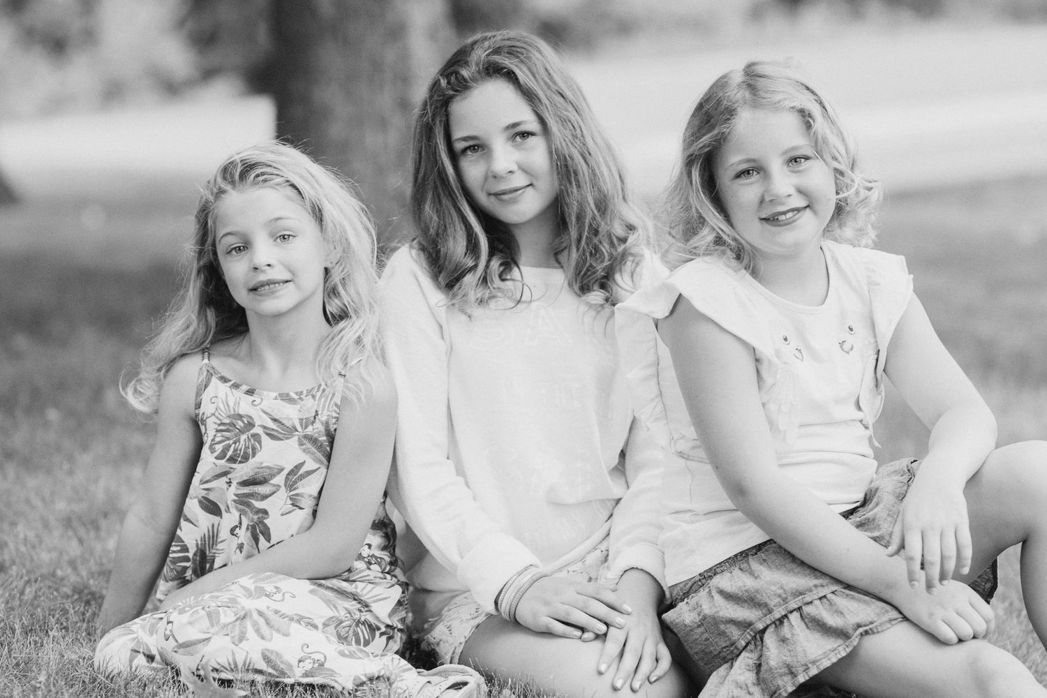 A collection of black and white family portraits showing joyful moments and natural interactions outdoors.