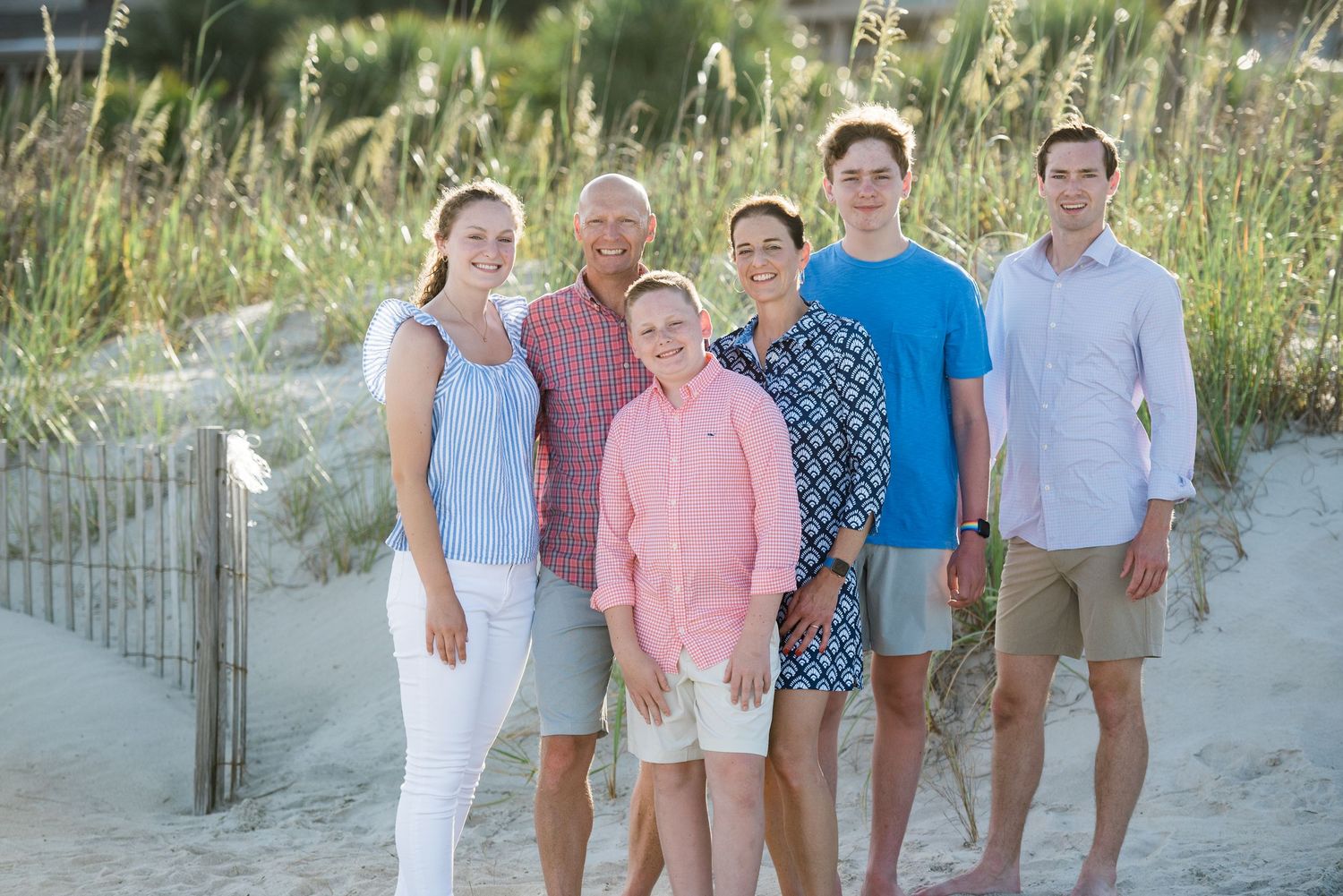 Summer beach gathering with group posed along sandy path near dune grass.Hammock Beach, Sea Pines coastal photography.