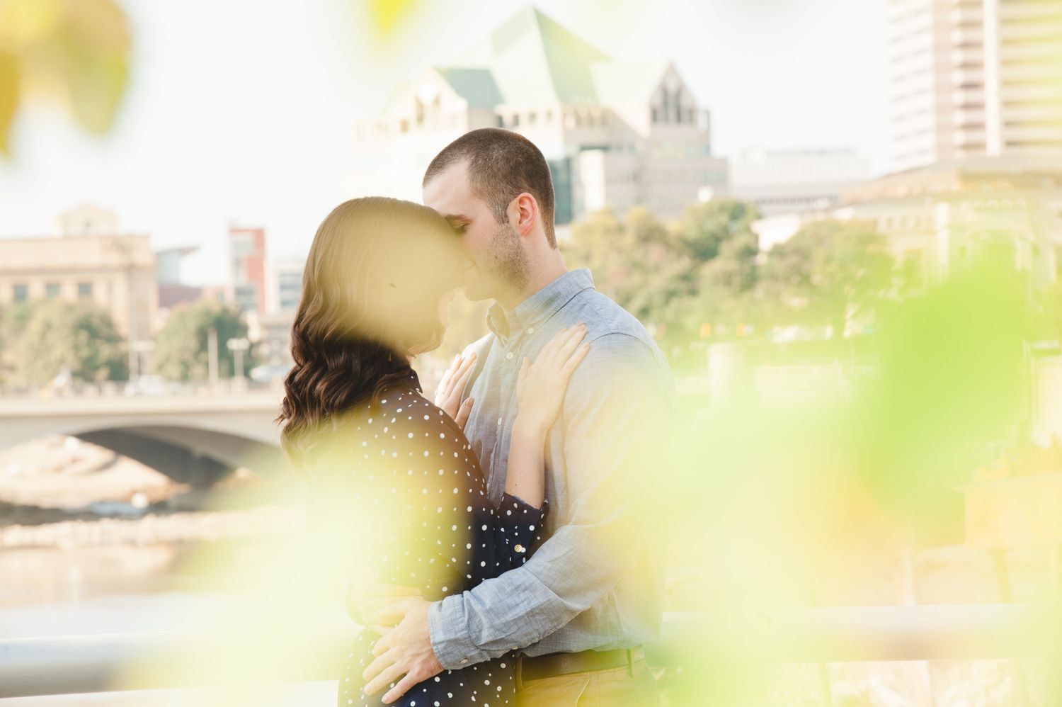 Couple shares intimate moment in urban setting with soft bokeh lighting effects.Downtown Columbus,Ohio