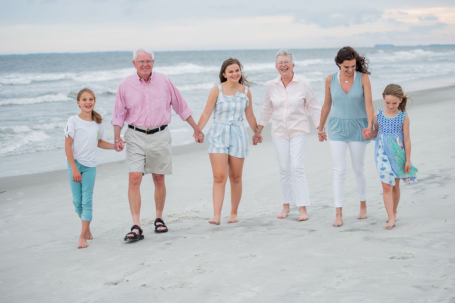 Family members walking together on beach in pastel colored clothing. St. Augustine Beach Florida Family Portrait.Hammock Beach, Sea Pines co