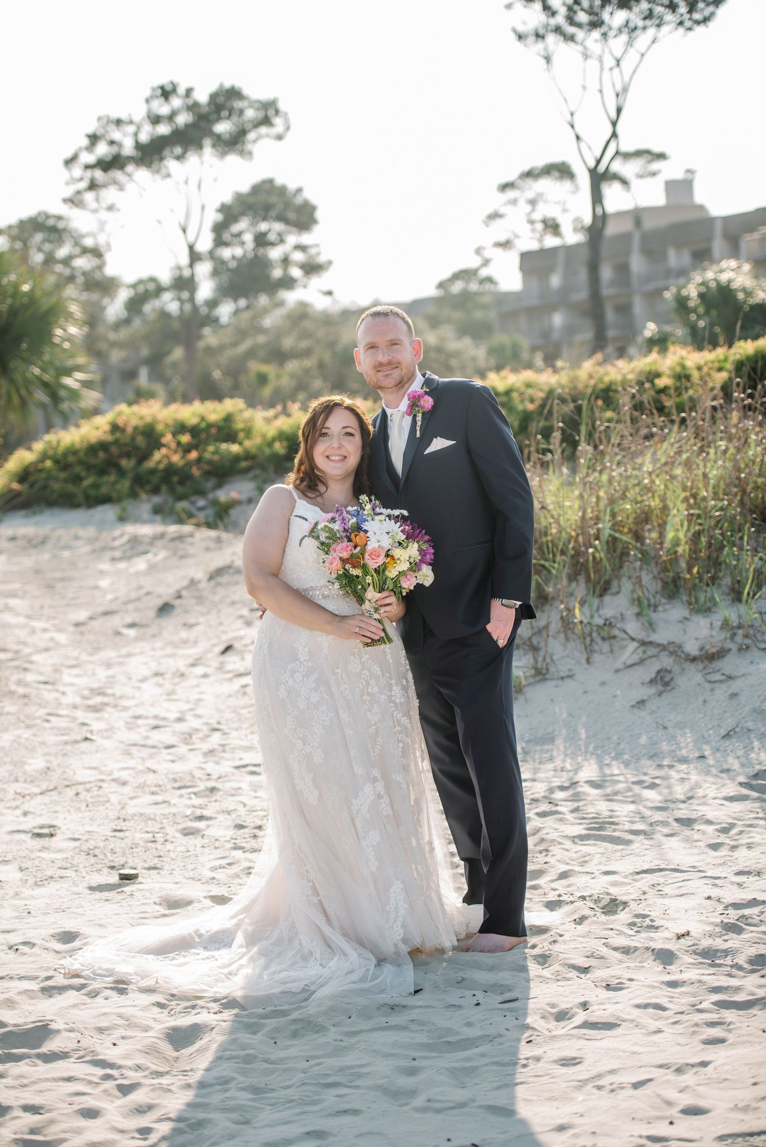 Romantic beach wedding portraits with sand dunes and coastal vegetation in the background. Hilton Head.