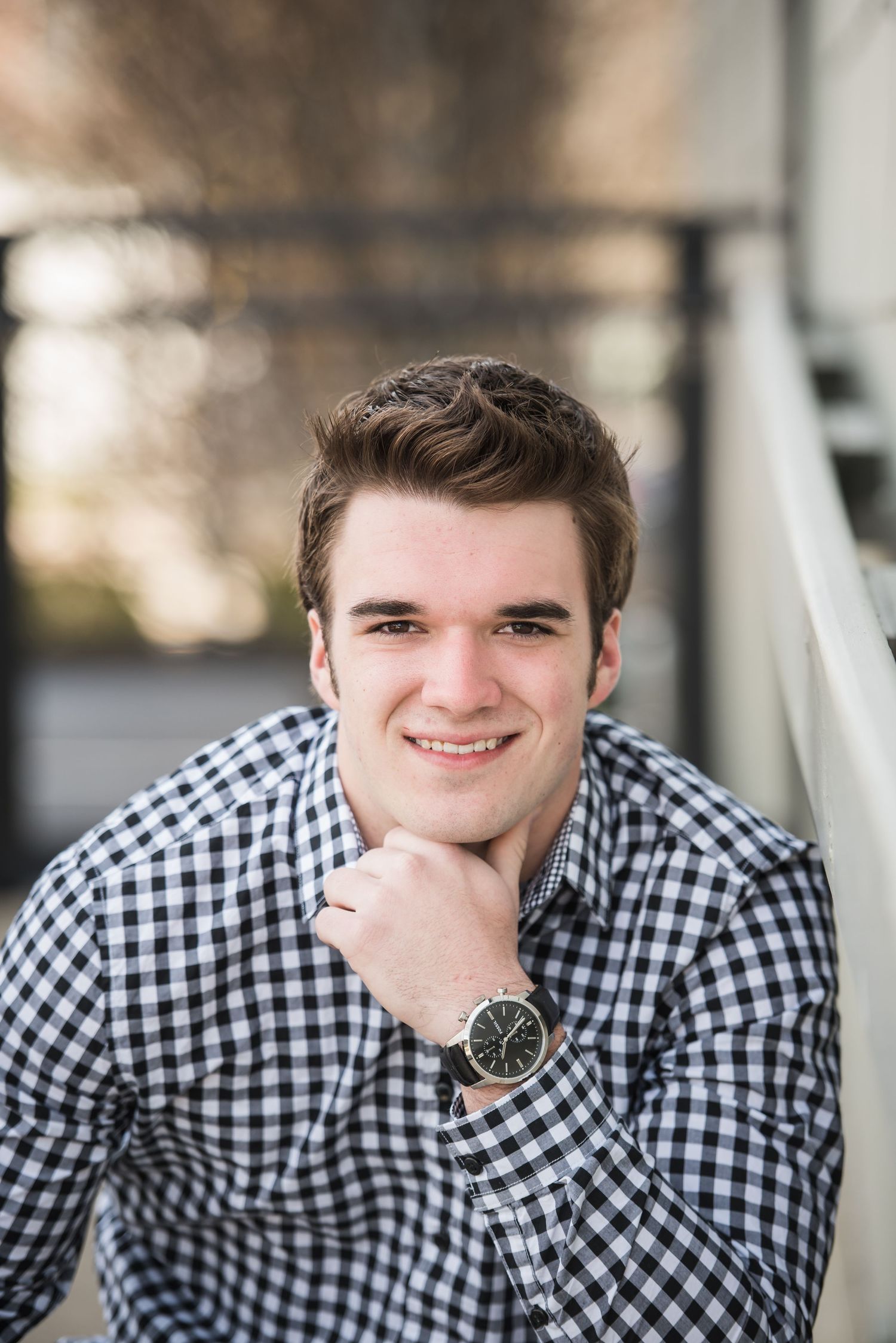 A series of four headshots showing someone wearing a black and white checkered button-up shirt and wristwatch.
