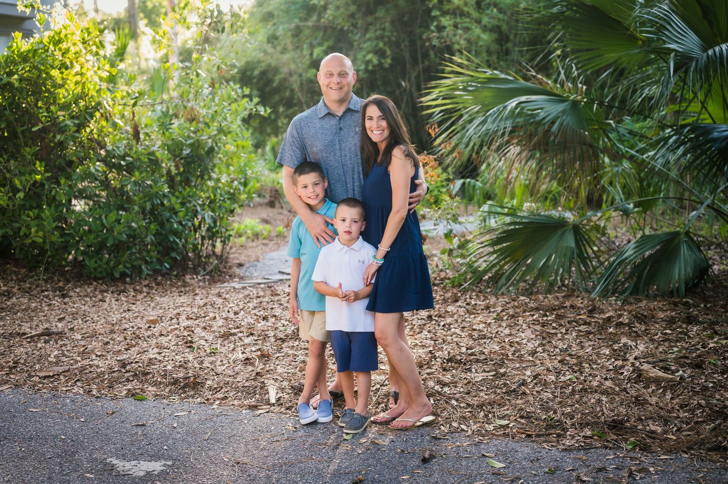 Family gathering captured in natural outdoor setting with palm trees and mulched pathway.Hammock Beach, Sea Pines coastal photography.