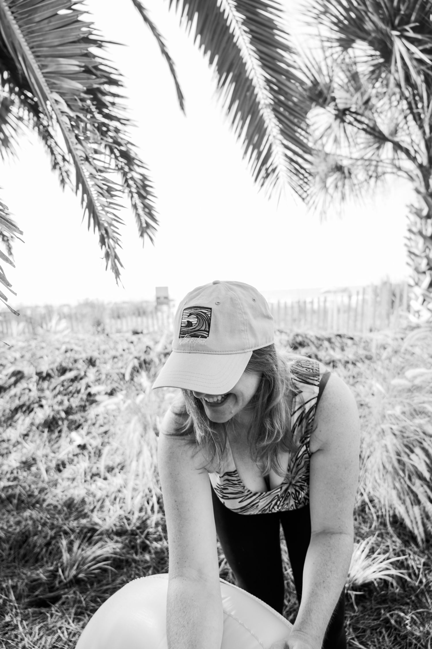 Black and white photo series showing someone sitting under palm trees in a contemplative pose.