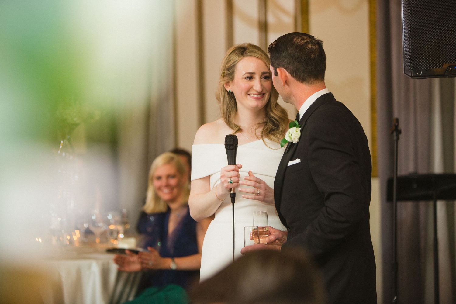 Wedding reception speech moment in an elegant venue with soft lighting.