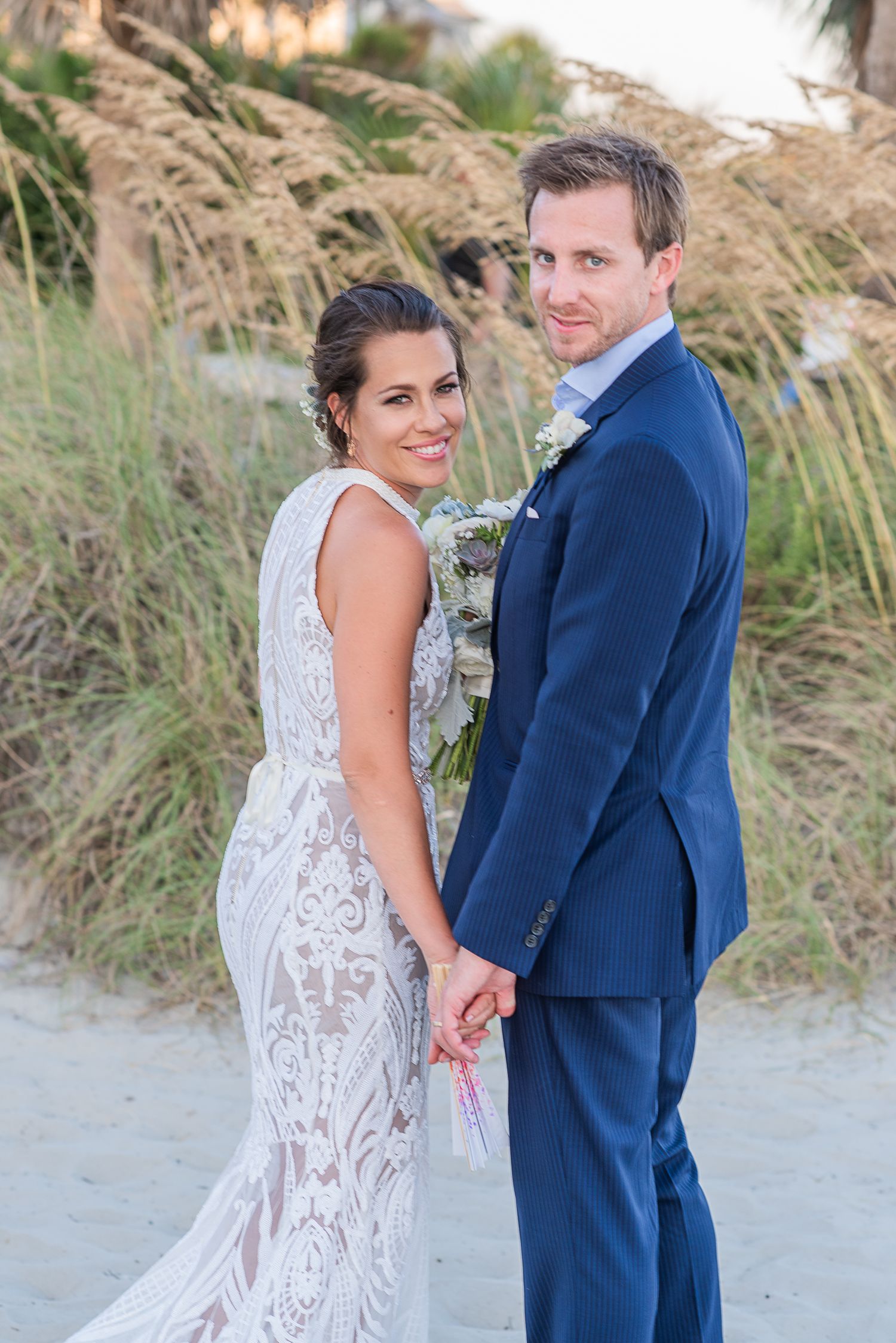 Romantic beach wedding photos with couple in navy suit and lace dress. St. Augustine Beach Wedding.