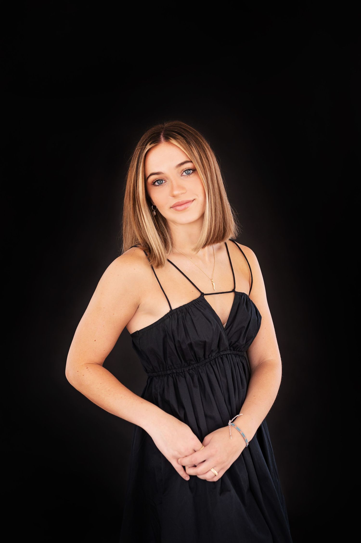 Dramatic black and white portraits against dark background in formal attire.