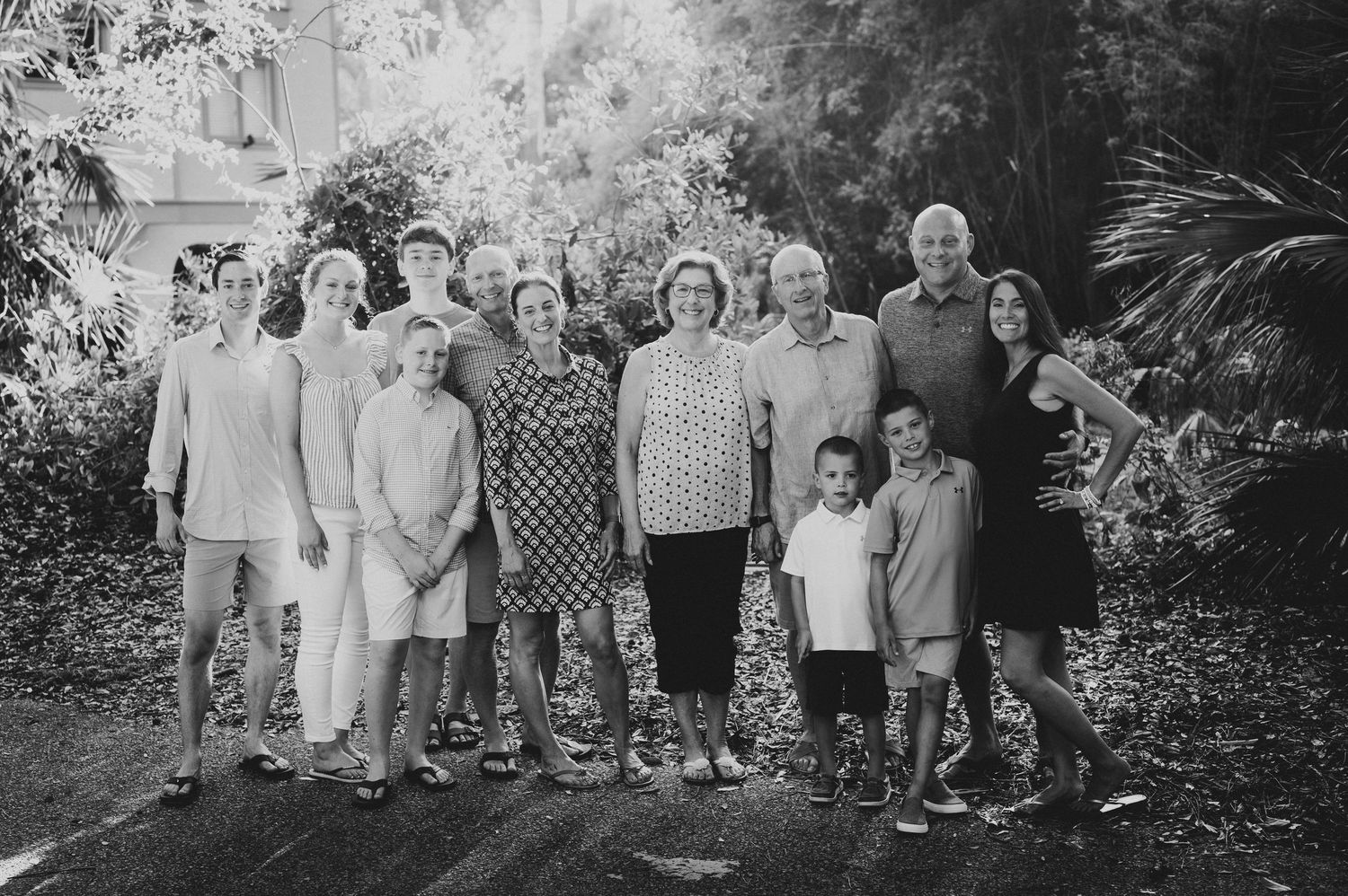 Black and white portrait of extended family gathered outdoors in natural setting.