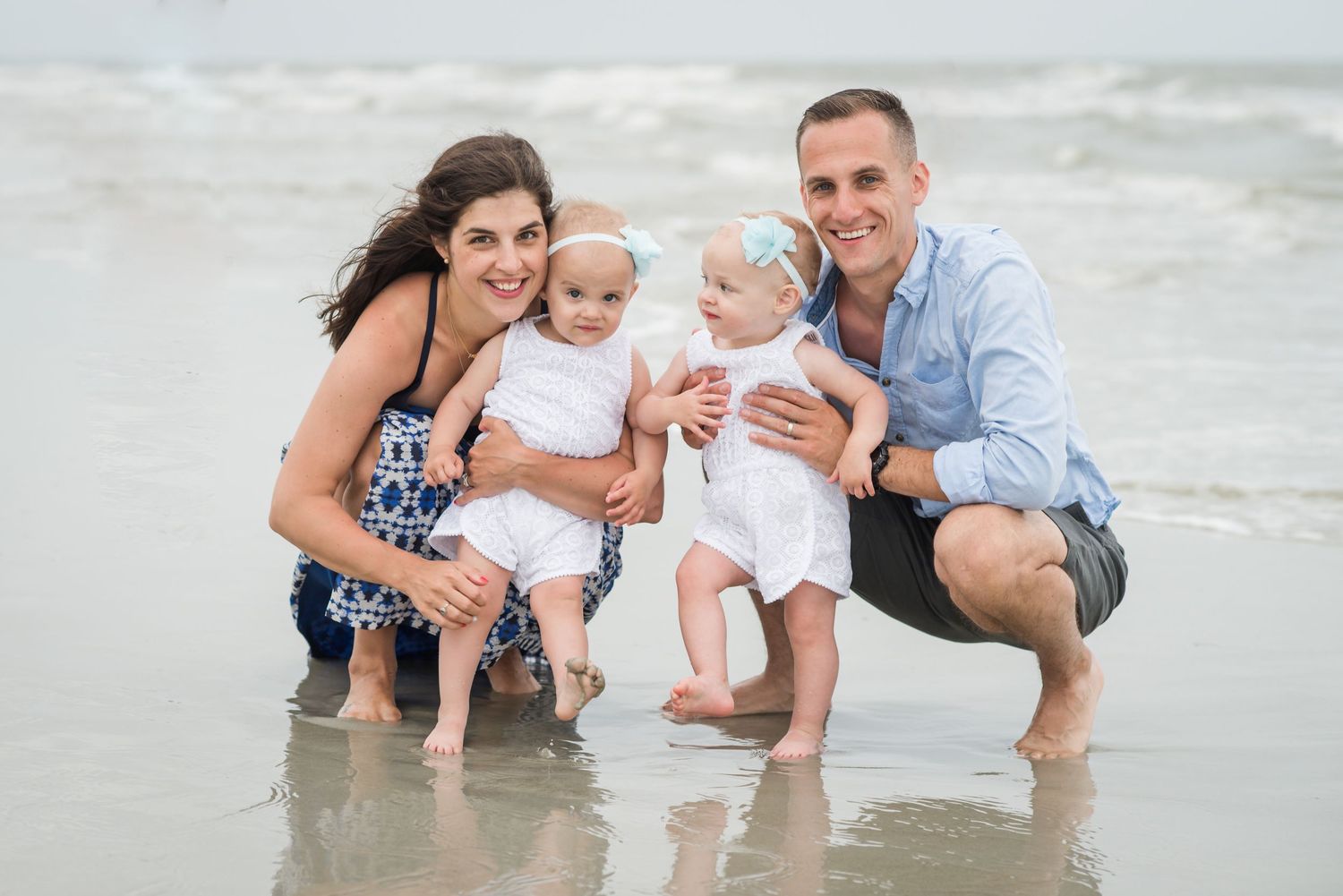 Family playing together and splashing in shallow ocean waves at the beach during sunset. St. Augustine Beach, Hammock Beach photographer.