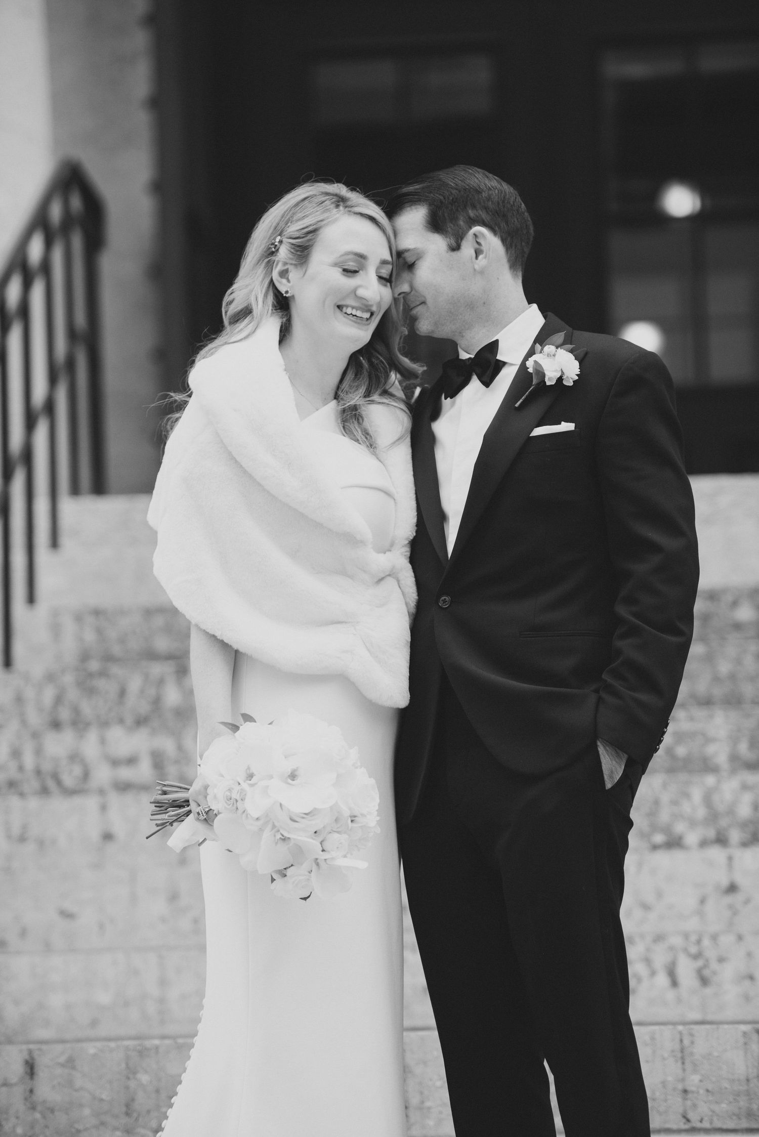 A romantic black and white wedding photo series showing tender moments between a bride and groom on stone steps.