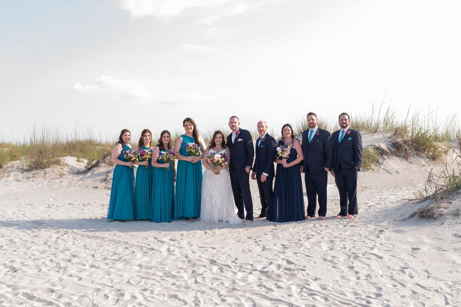 Wedding party group photos on a beach with bridesmaids in teal dresses and groomsmen in dark suits. Hilton Head