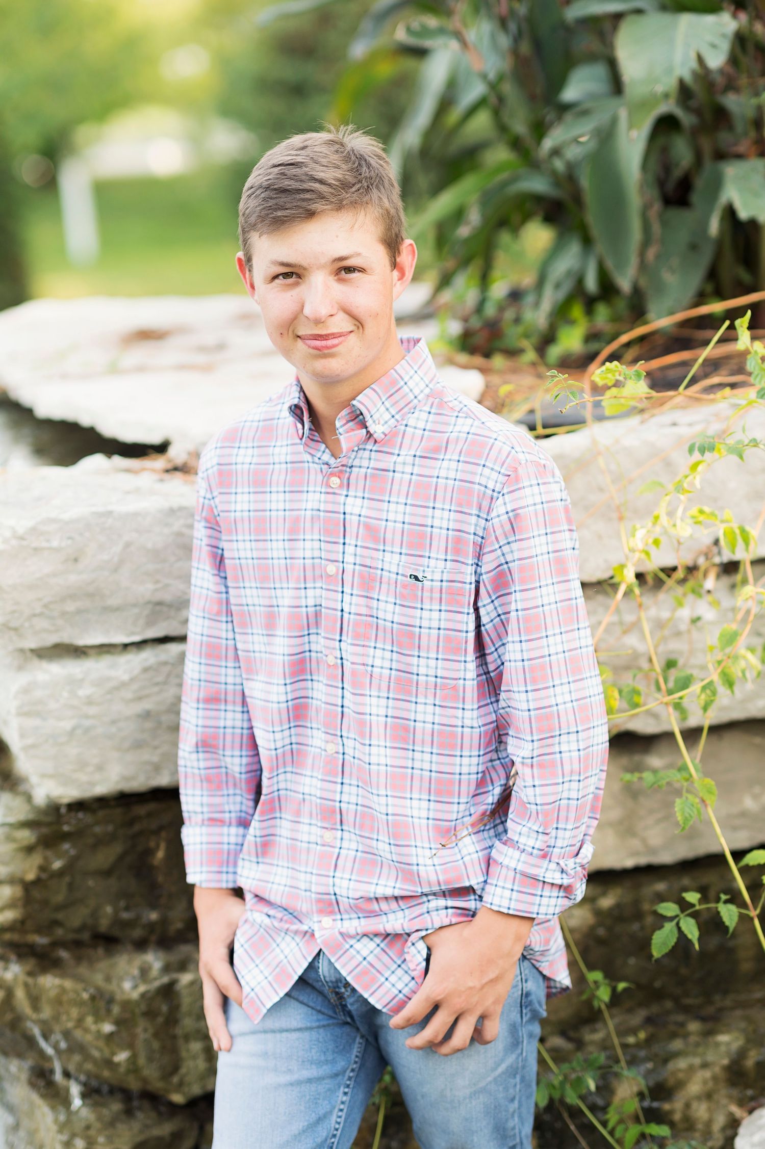 A series of casual outdoor portrait photos showing someone in a red and white plaid shirt against a natural stone backdrop.