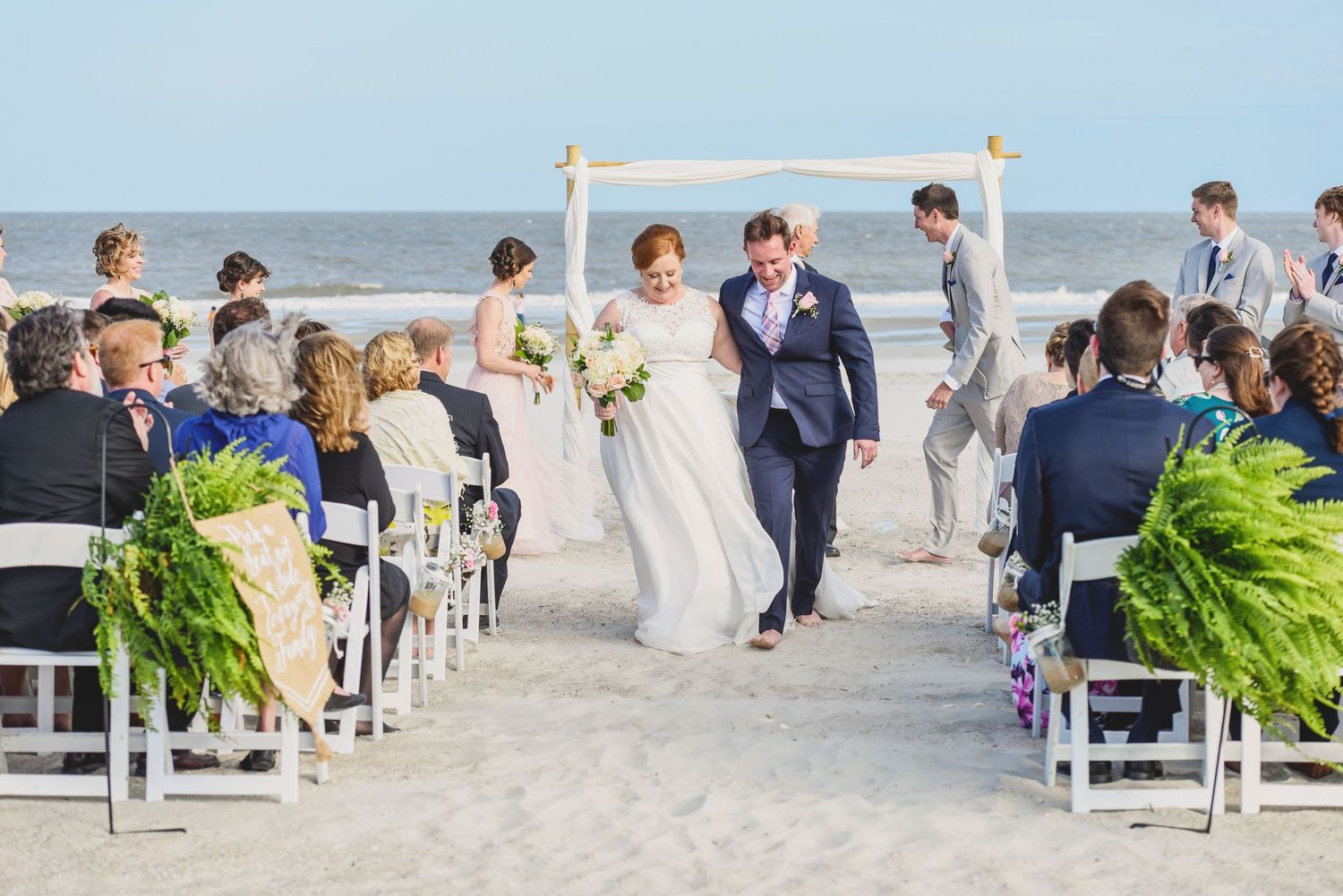 Beach wedding ceremony setup with white chairs and aisle on sandy shore.Hammock Beach, Sea Pines coastal photography.